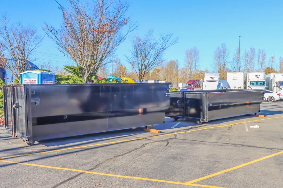 Professional dumpster rental service with roll-off container on residential driveway in Tecumseh